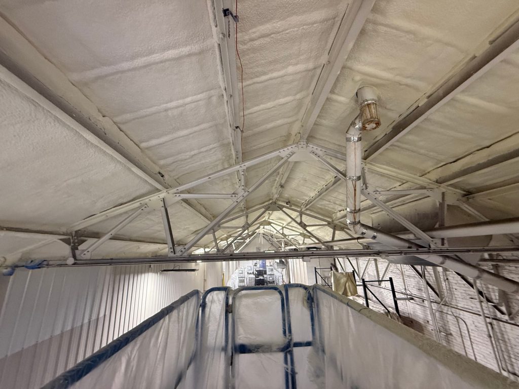 Spray foam on a commercial building roof and steel trusses